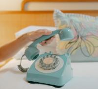 a person is holding a blue phone on a table at Ridley House - Key West Historic Inns in Key West