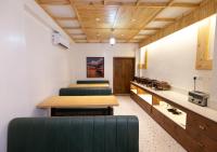 コルカタにあるThe Lake Palm Hotelのソファとテーブル付きの部屋、キッチンが備わる客室です。