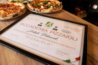 Tres pizzas sobre una mesa con un menú. en Zajazd Józef, en Witów