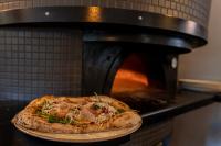 Una pizza está saliendo de un horno en Zajazd Józef, en Witów