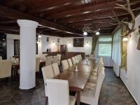 Un comedor con una mesa de madera y sillas blancas. en Senyői Vendégház, en Bózsva