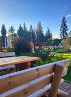 Una mesa de madera y una mesa de picnic en un parque. en Zajazd Józef, en Witów