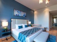 ein Schlafzimmer mit einem großen Bett mit einer blauen Wand in der Unterkunft Rixos The Palm Hotel &amp; Suites - Ultra All Inclusive in Dubai