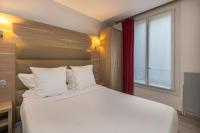 Un dormitorio con una gran cama blanca con ventana. en Hotel Luxor, en Issy-les-Moulineaux