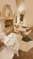 a room with tables and chairs and a fireplace at Hotel Palazzo Papaleo in Otranto