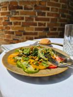 un plato de comida con una ensalada en una mesa en Hostellerie Du Château Les Muids, en La Ferté-Saint-Aubin