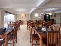 uma sala de jantar com mesas e cadeiras de madeira em Pousada do Albatroz em Cabo Frio