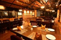 a restaurant with a large wooden table and chairs at Yagappa Heritage Resort - Near Lake & Bus Stand in Kodaikānāl