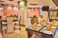 a restaurant with tables and chairs with yellow seats at Hotel Sun N Shine in Bhavnagar