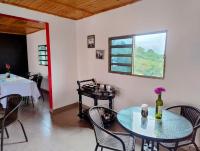 a dining room with a table and chairs and a window at Finca Hotel Santa Clara in Calarcá