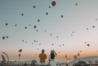 Una pareja mirando globos aerostáticos en el cielo. en Turan Cappadocia Cave, en Göreme