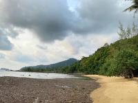 a sandy beach with trees on the side of the water at Koh Chang Bailan Beach Resort in Ko Chang