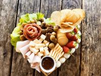 Mirante Cabanas da Serra في Nonoai: طبق طعام على شكل قلب موضوع على طاولة خشبية