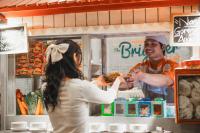 a man and a woman standing at a food stand at HARRIS Hotel Batam Center in Batam Center