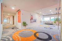 a large room with a carpet with a painting on the wall at HARRIS Hotel Batam Center in Batam Center