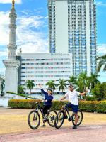 a man and a woman riding bikes in front of a building at HARRIS Hotel Batam Center in Batam Center