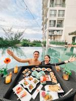 two people sitting at a table with food in the water at HARRIS Hotel Batam Center in Batam Center