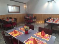 un comedor con mesas y sillas con flores. en Les pierres roses, en Coise