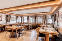 LenzVal Saraina Apartments的有木桌椅和窗户的餐厅