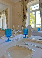 a table with blue glasses on a white table cloth at PortoBay Serra Golf in Santo António da Serra
