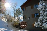 a building with a sign in front of it in the snow at Gästehaus by Stoos Hotels in Stoos