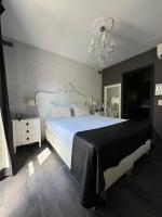 a bedroom with a large white bed and a chandelier at L&#39;écrin des Vennes - Liège centre in Liège