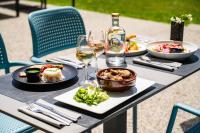 una mesa con platos de comida y copas de vino en SOWELL HOTELS Les Chevaliers, en Carcassonne