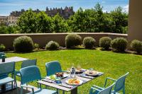 Una mesa y sillas con comida en el césped. en SOWELL HOTELS Les Chevaliers, en Carcassonne