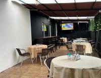 ボゴタにあるHotel Embajada Bogotaのテーブルと椅子とテレビのあるダイニングルーム