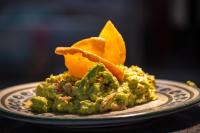 een bord met eten, guacamole en sinaasappelschijfjes bij La Dulce Vista Hotel & Villas - Sierra Madre Puerto Vallarta in Puerto Vallarta