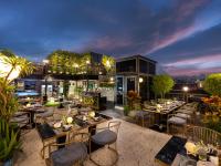 a restaurant on the roof of a building with tables and chairs at L'Signature Hotel & Spa in Hanoi
