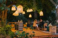 Die BrugKruger Untamed - Satara Plains Camp的坐在树下桌子上的男人和女人