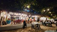een restaurant met tafels en stoelen op het strand 's nachts bij Evangeline Resort in Pagudpud