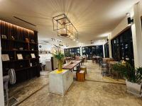 ein Restaurant mit Tischen und Stühlen und einem Kronleuchter in der Unterkunft Zenery Lake Resort in Ban Don Klang