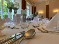 een tafel met zilveren bestek op een witte tafeldoek bij Schloss Schlemmin in Schlemmin