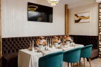 a table in a restaurant with blue chairs and flowers at Pensiunea Natalya in Bacău