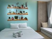 a room with a bed with plants on shelves at Beat Hotel Bangkok in Bangkok