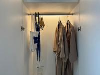 a closet with coats and umbrellas hanging at Beat Hotel Bangkok in Bangkok
