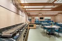 um restaurante com mesas e cadeiras e um balcão com pias em Stae Hotel-Madhapur em Hyderabad