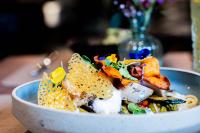 Un tazón de comida con chips de maíz y verduras. en Hotel Das Zeit, en Lenzing
