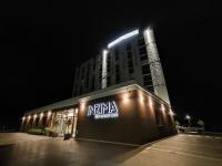 Un edificio con un cartel de naniemia en la parte superior por la noche. en Hotel Das Zeit, en Lenzing