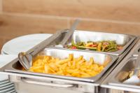 a tray of food with french fries and vegetables at Hôtel La Rose Blanche Korhogo in Korhogo