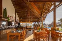 um restaurante com mesas e cadeiras de madeira e uma piscina em Lofts Collection by The Coral em Trairi