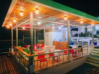 um restaurante com cadeiras vermelhas e mesas num deque em Tulang Diot View Resort and Turtle Haven em Camotes Islands