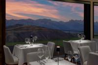 a restaurant with white tables and chairs and a view of mountains at Hotel Yellowstone at Jackson Hole in Jackson