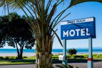 a sign for a motel next to a palm tree at Ohope Beach Motel in Ohope Beach