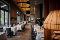 um restaurante com mesas, cadeiras e lâmpadas brancas em The George Hamburg em Hamburgo