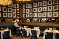 um homem parado em frente a uma mesa num restaurante em The George Hamburg em Hamburgo