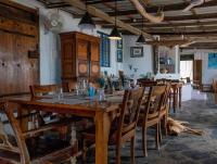 a dining room with a large wooden table and chairs at Aqua Outback in Tuticorin