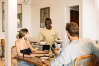 een groep mensen die rond een tafel zitten en eten bij Mala Boutique Hotel in Bwejuu